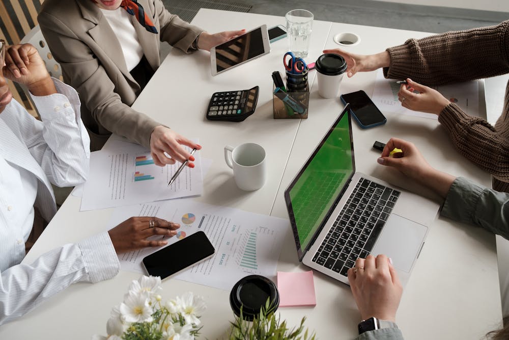 Tecnología para la Vida TXLV - Micro Magazine de FUNTESO, Fundación Tecnología Social imagen de una mesa de trabajo con diversos elementos de escritorio y oficina en la que destacan las manos de varias personas trabajando